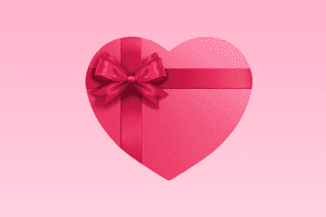 Ein Herz umbunden mit einer roten Schleife als Darstellung für ein Valentinstag Geschenk für Frauen